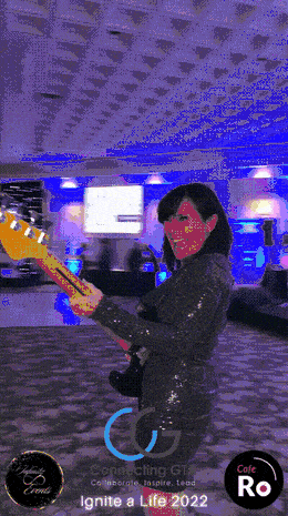 Guest laughing with a guitar prop as the 360 booth camera revolves around them